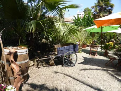 a blue cart sitting next to a barrel and an umbrella at Relais de Bravone in Linguizzetta