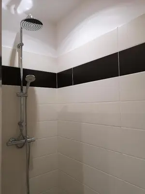 a shower with black and white stripes in a bathroom at T3 vue mer à Propriano in Propriano