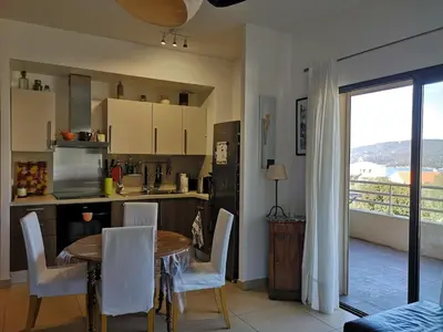 a kitchen with a table and chairs and a kitchen with a window at T3 vue mer à Propriano in Propriano