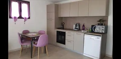 a kitchen with pink chairs and a table in it at Appartement Caroline in Sotta