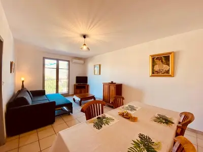 a living room with a table and a couch at Joli deux pièces, centre ville et proche plage in Propriano