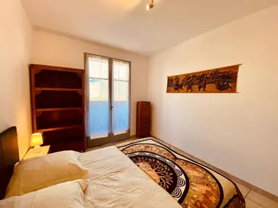 a bedroom with a bed and a window at Joli deux pièces, centre ville et proche plage in Propriano