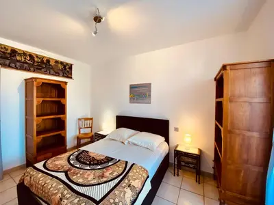 a small bedroom with a bed and a table and chairs at Joli deux pièces, centre ville et proche plage in Propriano