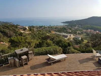 a bench on a deck with a view of the ocean at VILLA GIOIA -Vue mer- proche plage de Favone in Conca