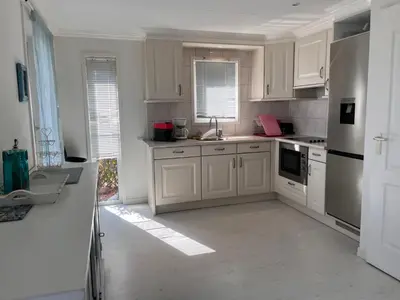 a kitchen with white cabinets and white appliances at VILLA GIOIA -Vue mer- proche plage de Favone in Conca