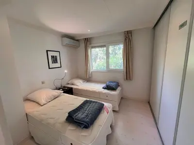 a small bedroom with two beds and a window at VILLA GIOIA -Vue mer- proche plage de Favone in Conca
