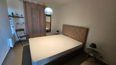 a small bedroom with a white bed and a chair at DOLCE VITA in Kamiesch