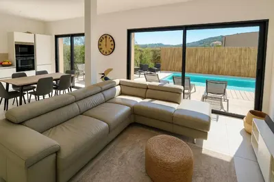 a living room with a couch and a table and a pool at Villa Moderne de Standing avec Piscine Privée à 400m de la Plage - 4 Chambres in Conca