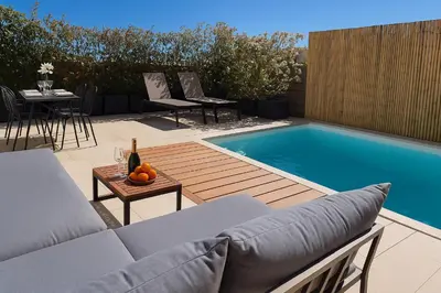 a swimming pool in a backyard with a couch and a table at Villa Moderne de Standing avec Piscine Privée à 400m de la Plage - 4 Chambres in Conca