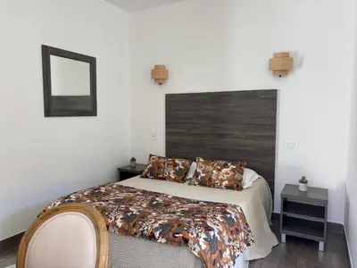 a bedroom with a large bed with a wooden headboard at Hotel U Campanile in Vivario