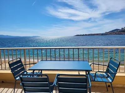 a table and chairs on a balcony overlooking the ocean at Sudio bord de mer Ajaccio in Ajaccio