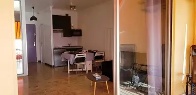a kitchen and a living room with a table and chairs at Sudio bord de mer Ajaccio in Ajaccio