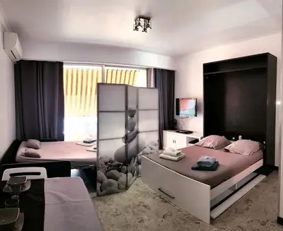 a bedroom with two beds and a desk and a table at Sudio bord de mer Ajaccio in Ajaccio