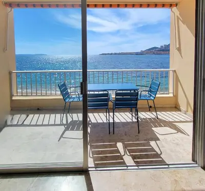a table and chairs on a balcony with the ocean at Sudio bord de mer Ajaccio in Ajaccio