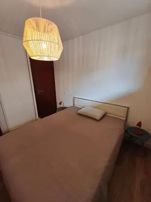 a bedroom with a large bed with a chandelier at Appartement T2 Bord de Mer - Maria Beach in Santa-Lucia-di-Moriani