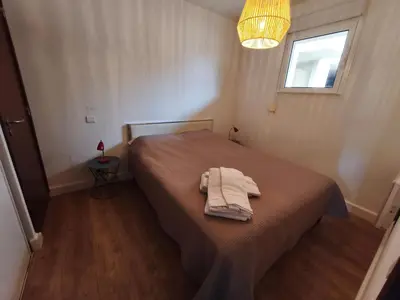 a bedroom with a bed with a robe on it at Appartement T2 Bord de Mer - Maria Beach in Santa-Lucia-di-Moriani