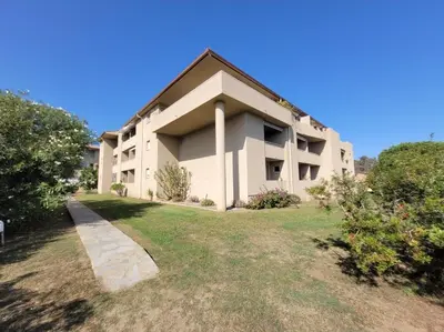 a large white building with a grass yard at Appartement T2 Bord de Mer - Maria Beach in Santa-Lucia-di-Moriani