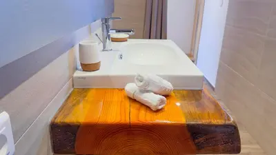 a bathroom with a sink and a towel on a wooden counter at Résidence de la Plage in Porto-Vecchio