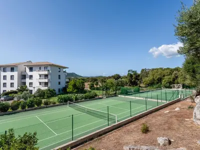 a tennis court with two tennis courts at Apartment Domaine d'Arca-3 by Interhome in Porto-Vecchio