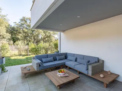a living room with a blue couch and tables at Apartment Domaine d'Arca-3 by Interhome in Porto-Vecchio