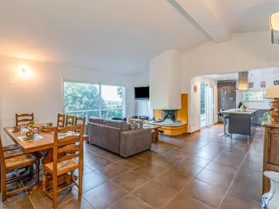 a living room with a dining table and a kitchen at Holiday Home Villa Boccajo by Interhome in Porto-Vecchio