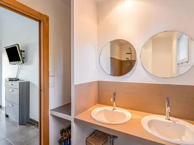 two sinks in a bathroom with two mirrors at Holiday Home Villa Boccajo by Interhome in Porto-Vecchio
