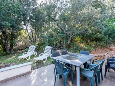 a table and chairs on a patio with trees at Holiday Home Villa Boccajo by Interhome in Porto-Vecchio