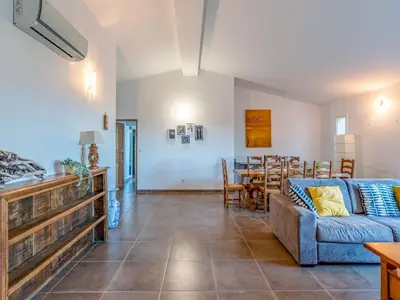 a living room with a couch and a table at Holiday Home Villa Boccajo by Interhome in Porto-Vecchio