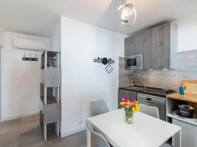 a kitchen with a white table and a white counter top at Holiday Home Signoria by Interhome in Sari Solenzara