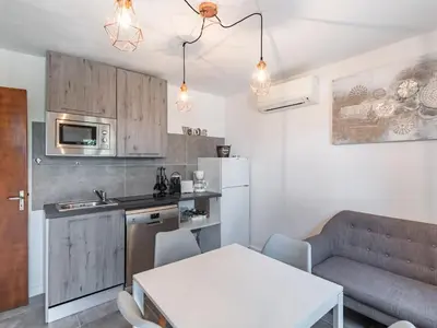 a dining room with a table and chairs and a tv at Holiday Home Sepia by Interhome in Sari Solenzara