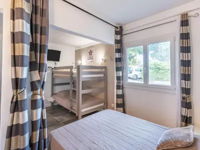 a bedroom with two bunk beds and a mirror at Holiday Home Sepia by Interhome in Sari Solenzara