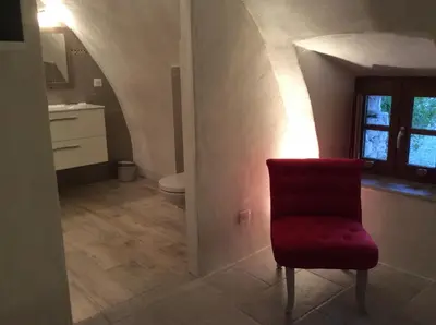 a bathroom with a red chair and a toilet at Casa Natalina de caractère entièrement rénovée classée 4 étoiles in Feliceto