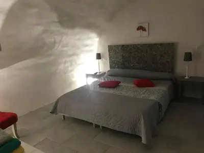 a bedroom with a bed with red pillows on it at Casa Natalina de caractère entièrement rénovée classée 4 étoiles in Feliceto
