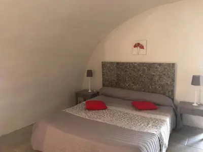 a bedroom with a bed with red pillows on it at Casa Natalina de caractère entièrement rénovée classée 4 étoiles in Feliceto