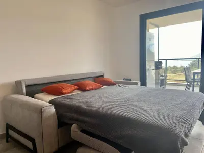 a bedroom with a bed with orange pillows on it at BEL'ORIZONTE Proche centre ville et plage, vue mer in Propriano