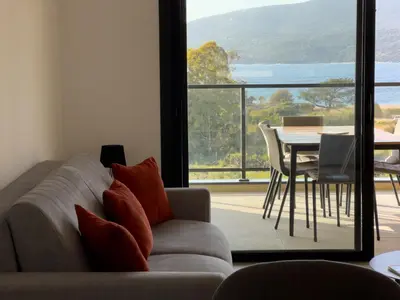 a living room with a couch and a table at BEL'ORIZONTE Proche centre ville et plage, vue mer in Propriano
