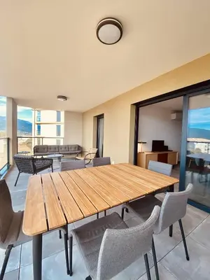 a dining room with a wooden table and chairs at BEL'ORIZONTE Proche centre ville et plage, vue mer in Propriano