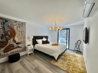 a bedroom with a bed and a painting on the wall at Fronte di Mare - Grand confort vue mer in Propriano