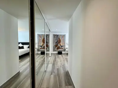 a hallway with a mirror and a bedroom with a bed at Fronte di Mare - Grand confort vue mer in Propriano