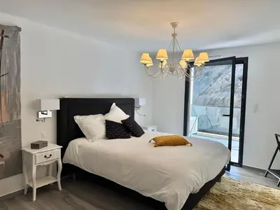 a bedroom with a large bed with a chandelier at Fronte di Mare - Grand confort vue mer in Propriano
