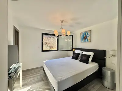 a bedroom with a bed with white sheets and pillows at Fronte di Mare - Grand confort vue mer in Propriano