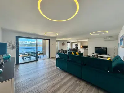 a living room with a green couch and a television at Fronte di Mare - Grand confort vue mer in Propriano