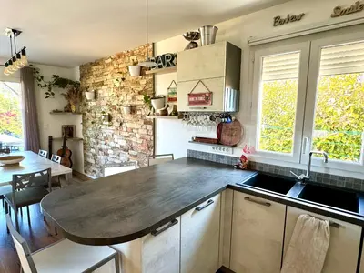 a kitchen with a table and a counter top at Jolie maison Borgo trois chambres trois salles de bain in Borgo