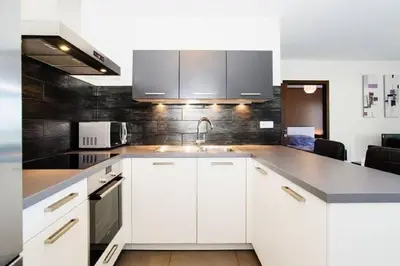a kitchen with white cabinets and a sink at T2 PORTICCIO AGOSTA PLAGE 100M DE LA PLAGE in Porticcio