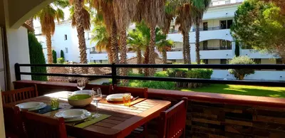 a table on a balcony with a view of a building at Evasion Corse Direct mer Piscine Terrasse in Moriani Plage