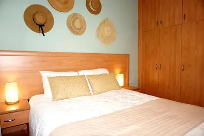 a bedroom with a bed with hats on the wall at Evasion Corse Direct mer Piscine Terrasse in Moriani Plage