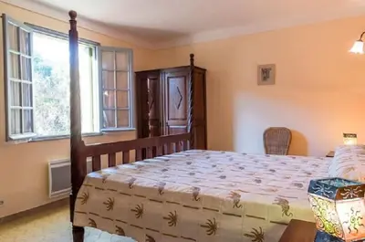 a bedroom with a large bed and a window at Appartement a Baracci in Olmeto