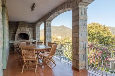 a dining room with a table and chairs on a balcony at Appartement a Baracci in Olmeto