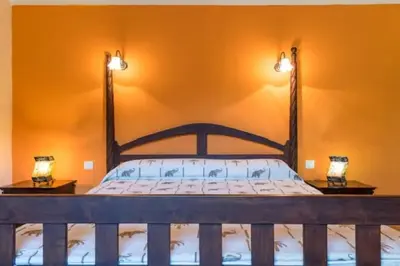 a bedroom with a bed with orange walls and two lamps at Appartement a Baracci in Olmeto