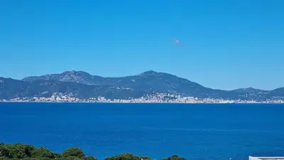 a view of a large body of water with mountains at Superbe appartement T3 face mer baie Ajaccio in Pietrosella